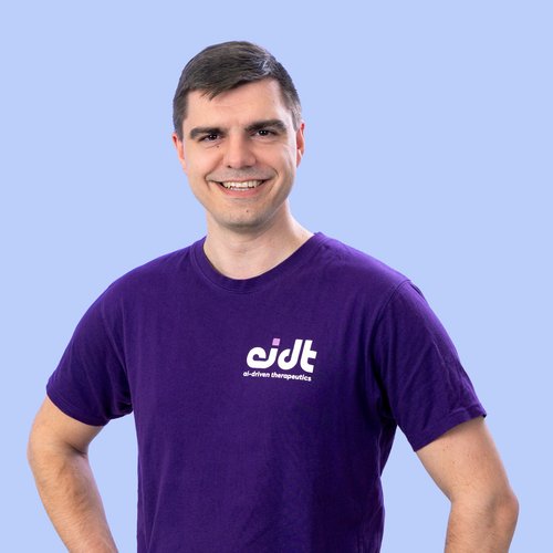Halborträt eines lächelnden Mannes im blauen T-Shirt mit Logo seiner Firma 
