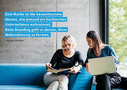 Corporate Design Zitatheader Zwei Frauen sitzen auf einer blauen Couch und unterhalten sich miteinander. Die rechte braunhaarige Frau hält einen Laptop auf den Knien. Die linke blonde Frau hält ein Buch. Bei schauen in das Buch. Auf dem Bild befindet sich das Zitat "Eine Marke ist die Gesamtsumme dessen, wie jemand ein bestimmtes Unternehmen wahrnimmt. Beim Branding geht es darum, diese Wahrnehmung zu formen. — Ashley Friedlein" mit cyanfarbiger Hinterlegung.